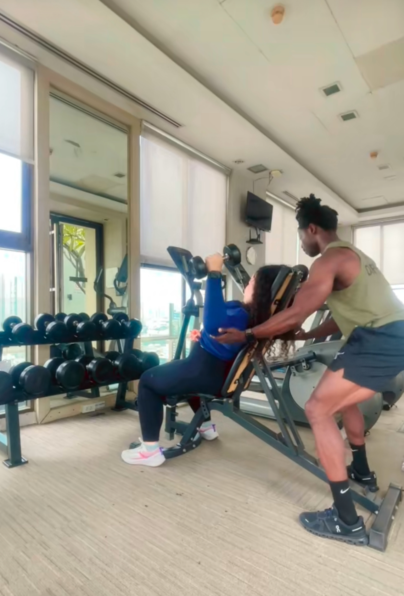 Coach guiding a client through a supported chest press in a private training studio